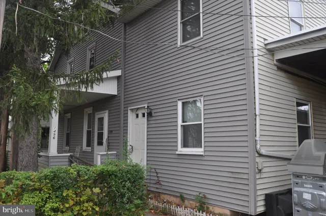 a view of a house with a small yard and potted plants
