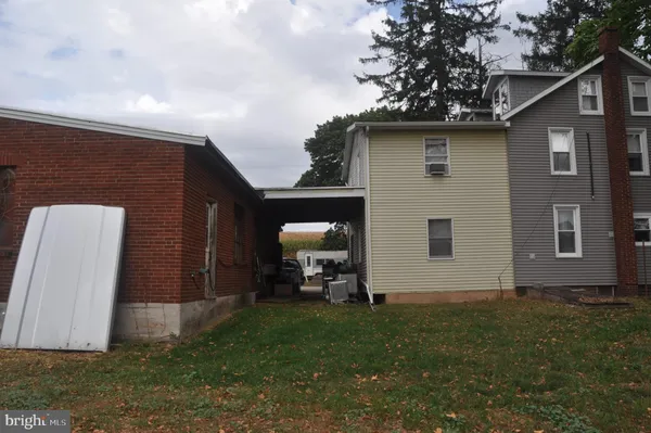 a view of a house with a yard and large tree