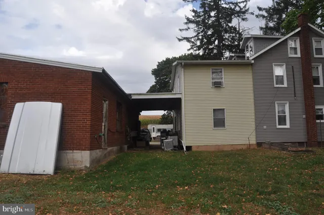a view of a house with a yard and large tree