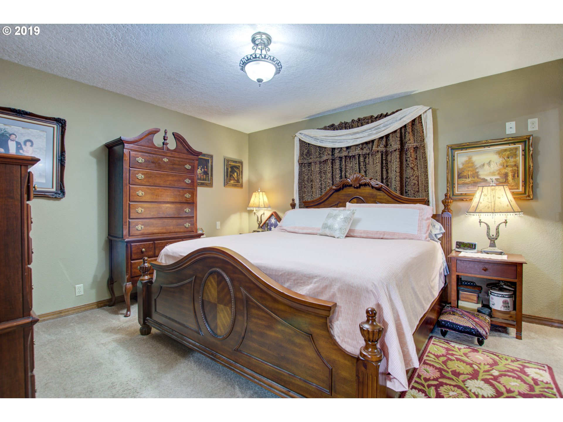 6180 Southeast Lusted Road Gresham, OR 97080 - Photo 15 of 30 a bedroom with a bed a chandelier and a mirror