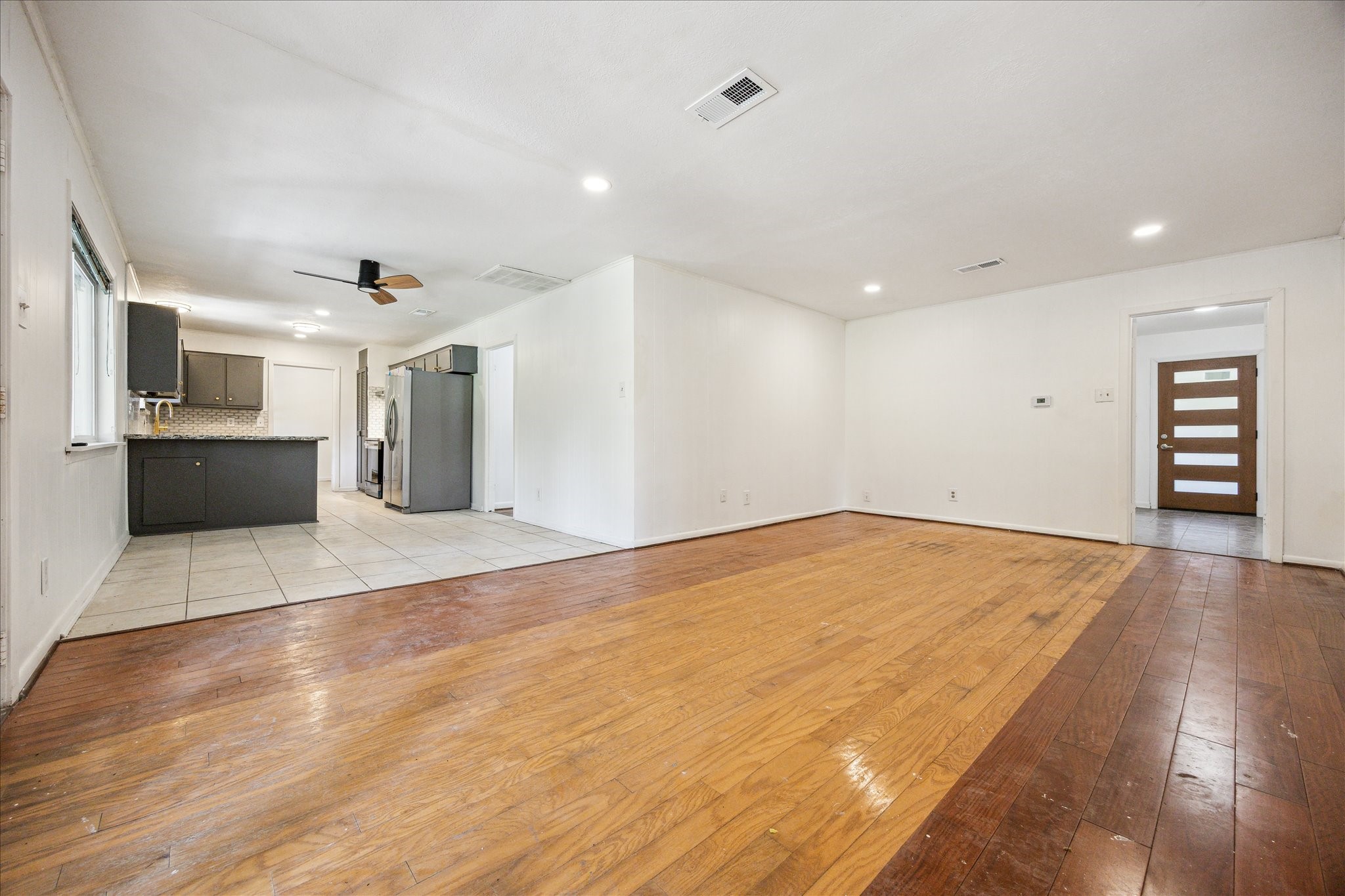 5419 Beechnut Street Houston, TX 77096 - Photo 27 of 28 Open floor plan featuring a den with wood flooring that connects seamlessly to the breakfast area and kitchen, creating a spacious flow for everyday living.