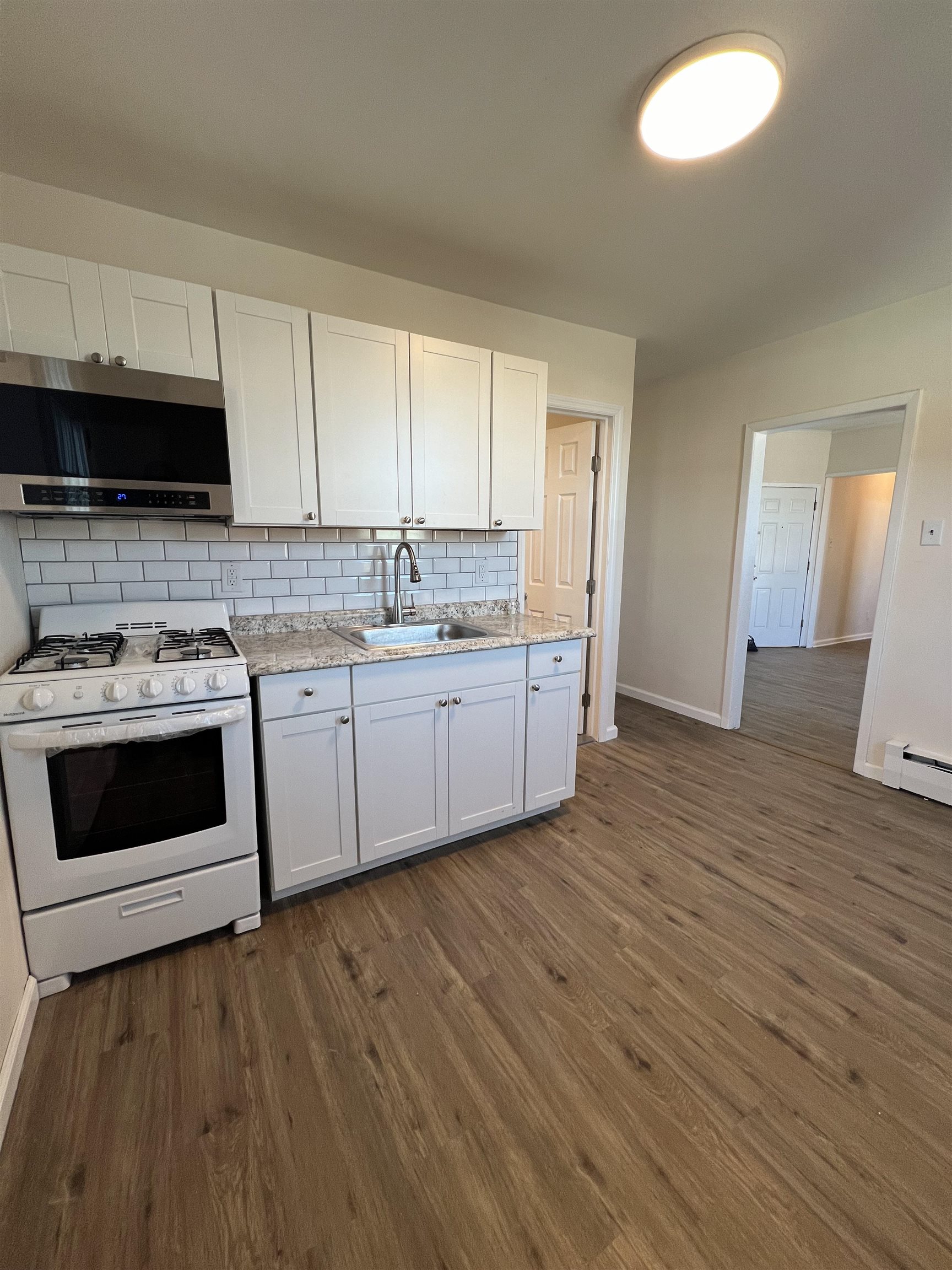 618 Broadway, Unit 5 Bayonne, NJ 07002 - Photo 2 of 9 a kitchen with a sink a stove and cabinets