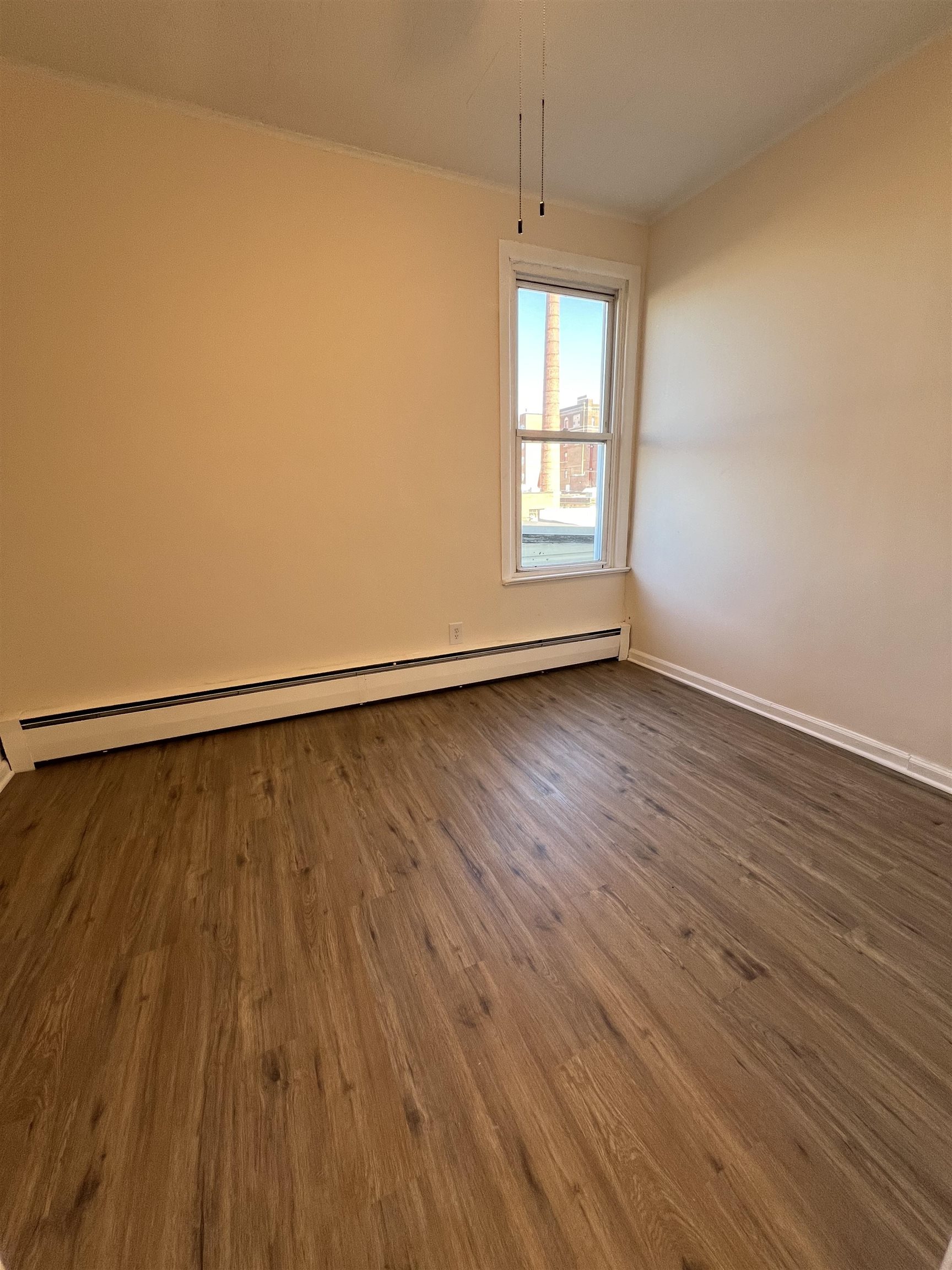 618 Broadway, Unit 5 Bayonne, NJ 07002 - Photo 7 of 9 wooden floor in an empty room with a window