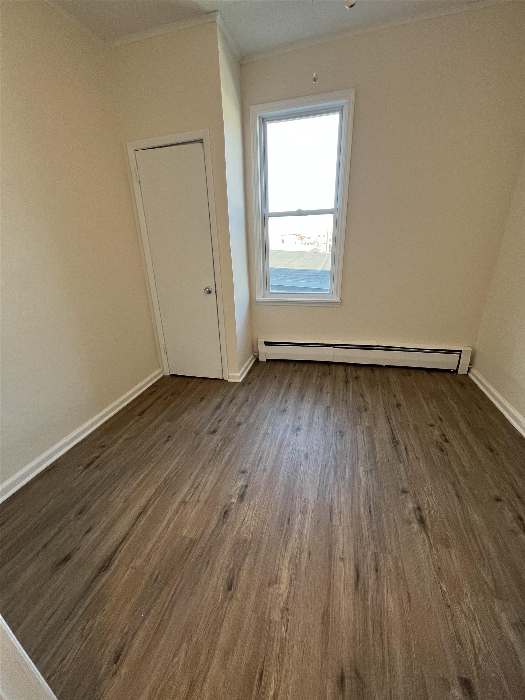 618 Broadway, Unit 5 Bayonne, NJ 07002 - Photo 8 of 9 an empty room with wooden floor and windows