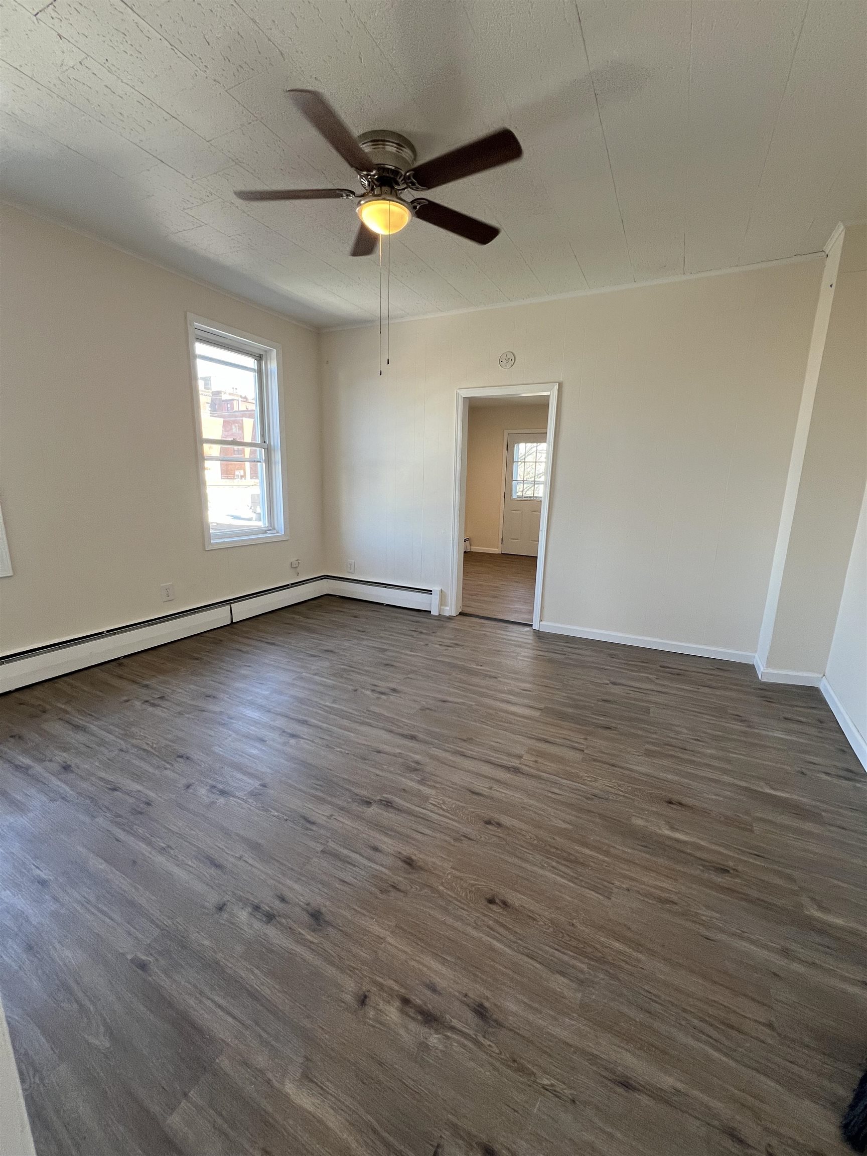 618 Broadway, Unit 5 Bayonne, NJ 07002 - Photo 9 of 9 an empty room with wooden floor and windows