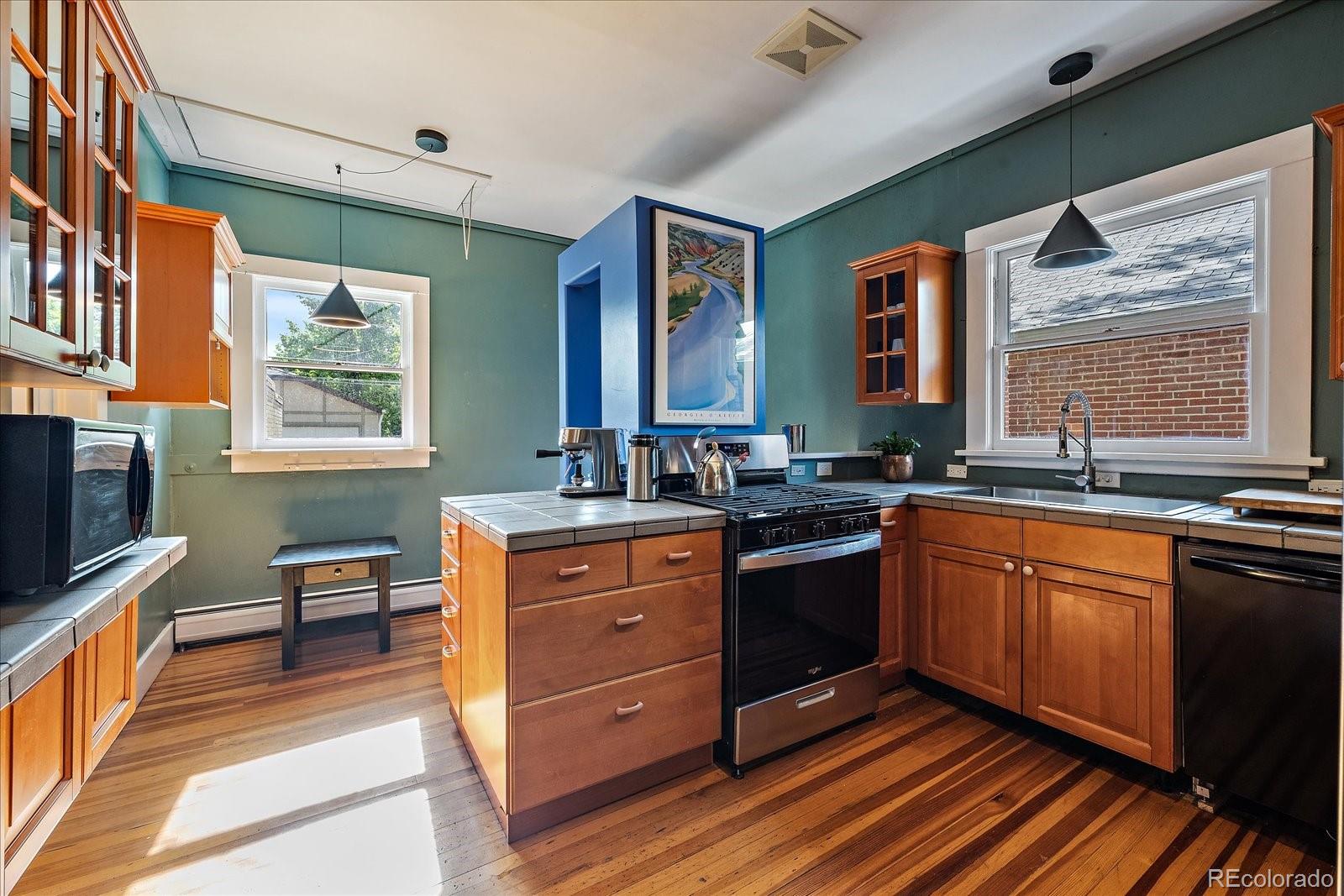 756 Steele Street Denver, CO 80206 - Photo 11 of 32 a large kitchen with stainless steel appliances granite countertop a sink stove and cabinets
