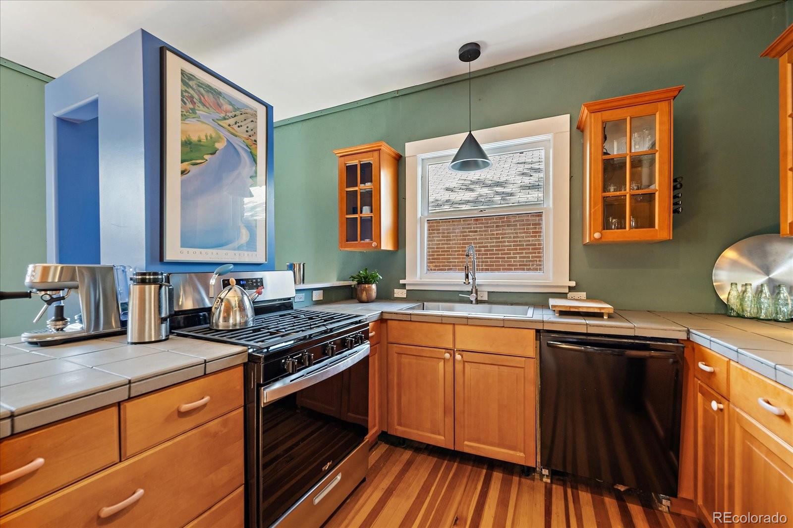 756 Steele Street Denver, CO 80206 - Photo 12 of 32 a kitchen with stainless steel appliances granite countertop a sink stove and cabinets