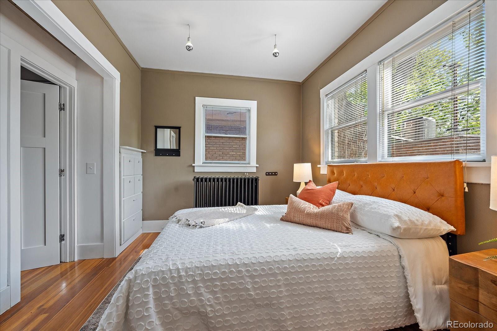 756 Steele Street Denver, CO 80206 - Photo 16 of 32 a bedroom with a bed and wooden floor