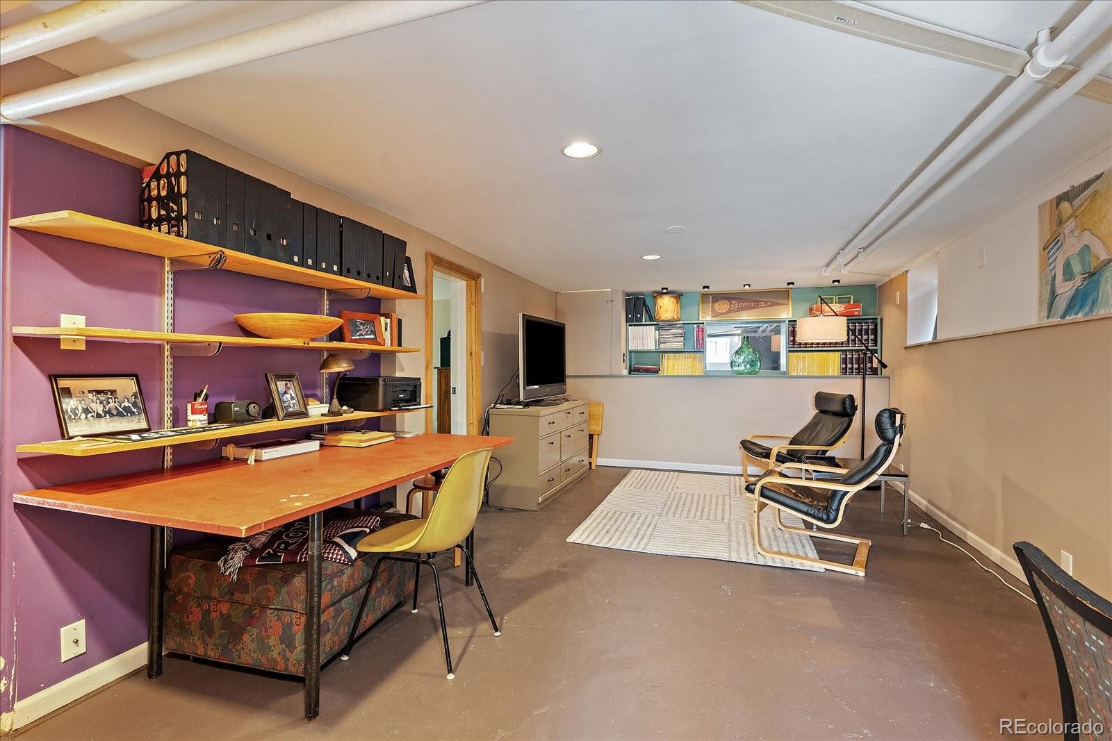 756 Steele Street Denver, CO 80206 - Photo 21 of 32 a living room with furniture a flat screen tv and kitchen view