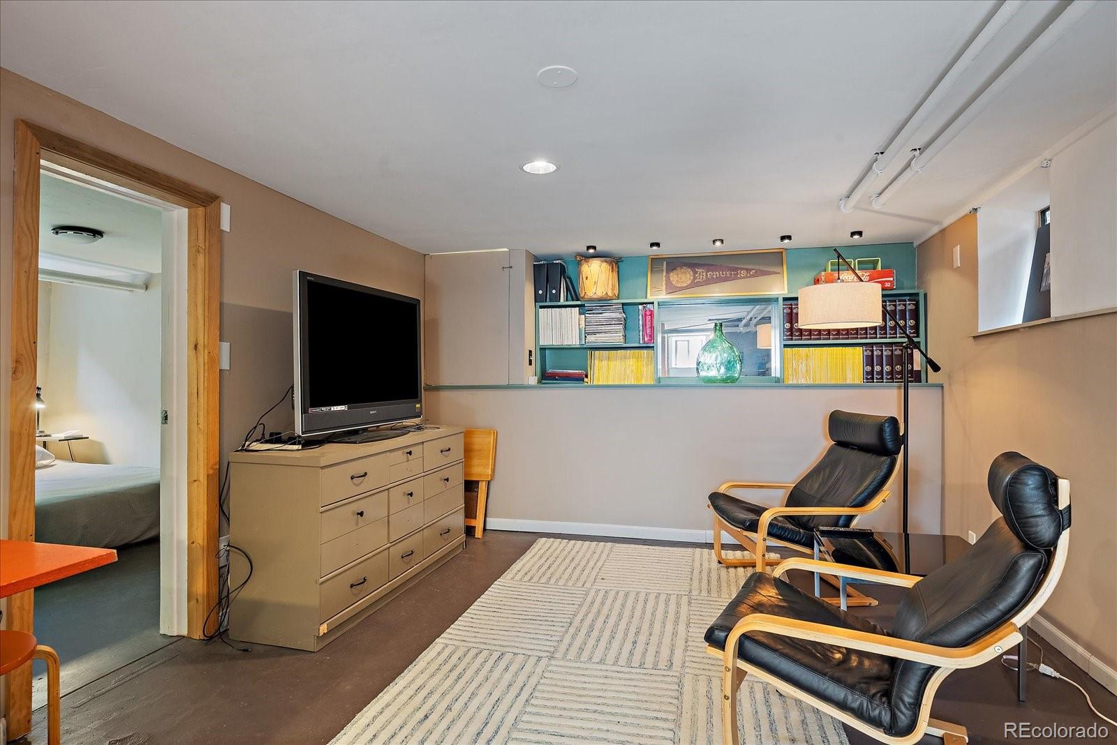 756 Steele Street Denver, CO 80206 - Photo 22 of 32 a room with furniture a flat screen tv and kitchen view