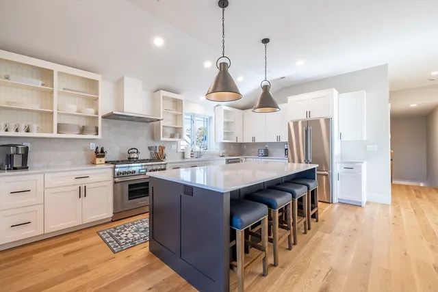 a kitchen with stainless steel appliances granite countertop a sink a stove and a wooden floors