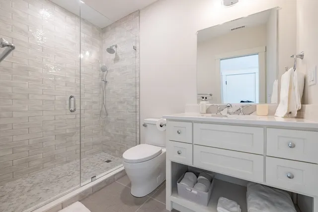a bathroom with a shower toilet sink and mirror