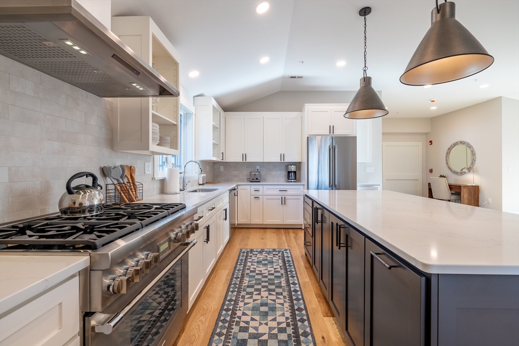 2 Punchard Avenue, Unit 3 Andover, MA 01810 - Photo 3 of 30 a kitchen with kitchen island stainless steel appliances a stove a sink a center island and windows