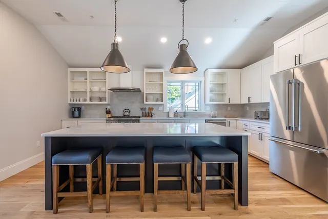 a kitchen with stainless steel appliances granite countertop a sink a refrigerator and a stove