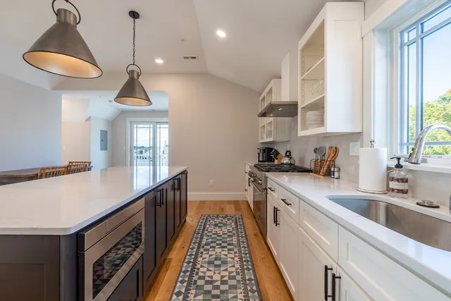 a kitchen with kitchen island granite countertop a sink and a stove