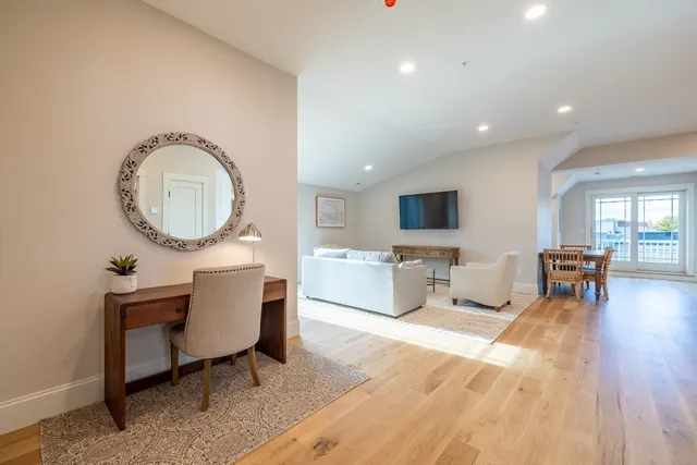 a living room with furniture a flat screen tv and kitchen view