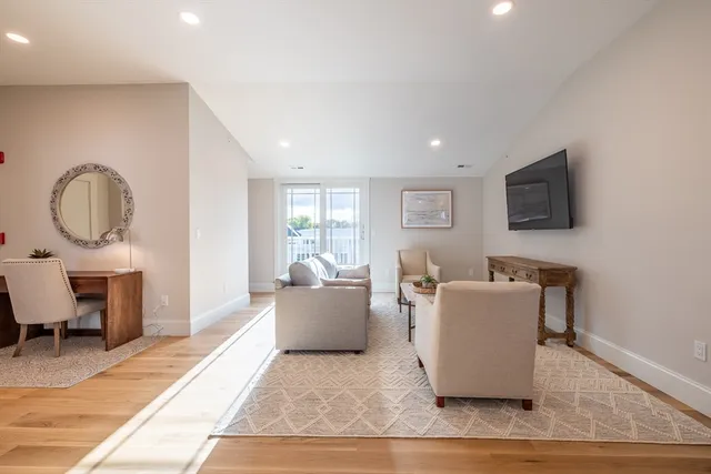 a living room with furniture a rug and a flat screen tv