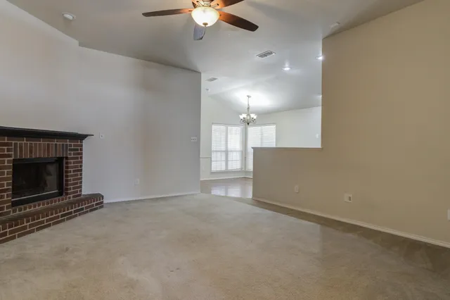 an empty room with a fireplace and fan