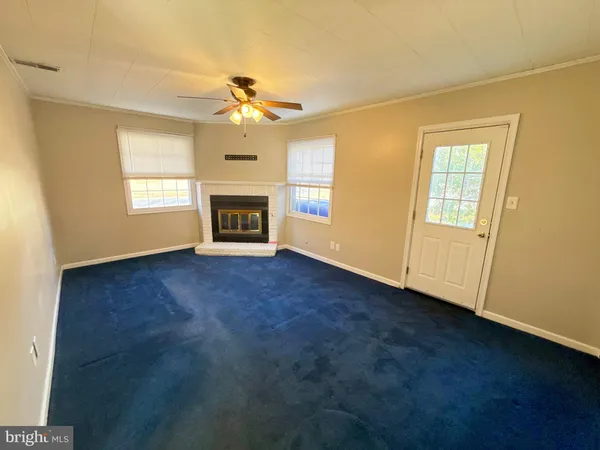 an empty room with windows and fireplace