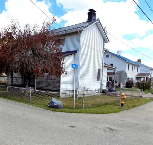 a view of a house with a patio and a yard