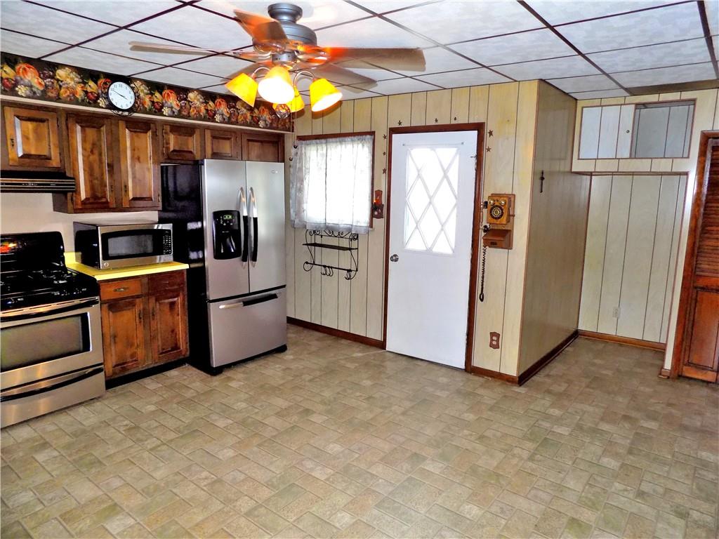 115 Rainey Avenue Uledi, PA 15484 - Photo 7 of 18 a kitchen with stainless steel appliances kitchen island granite countertop a refrigerator and a stove top oven