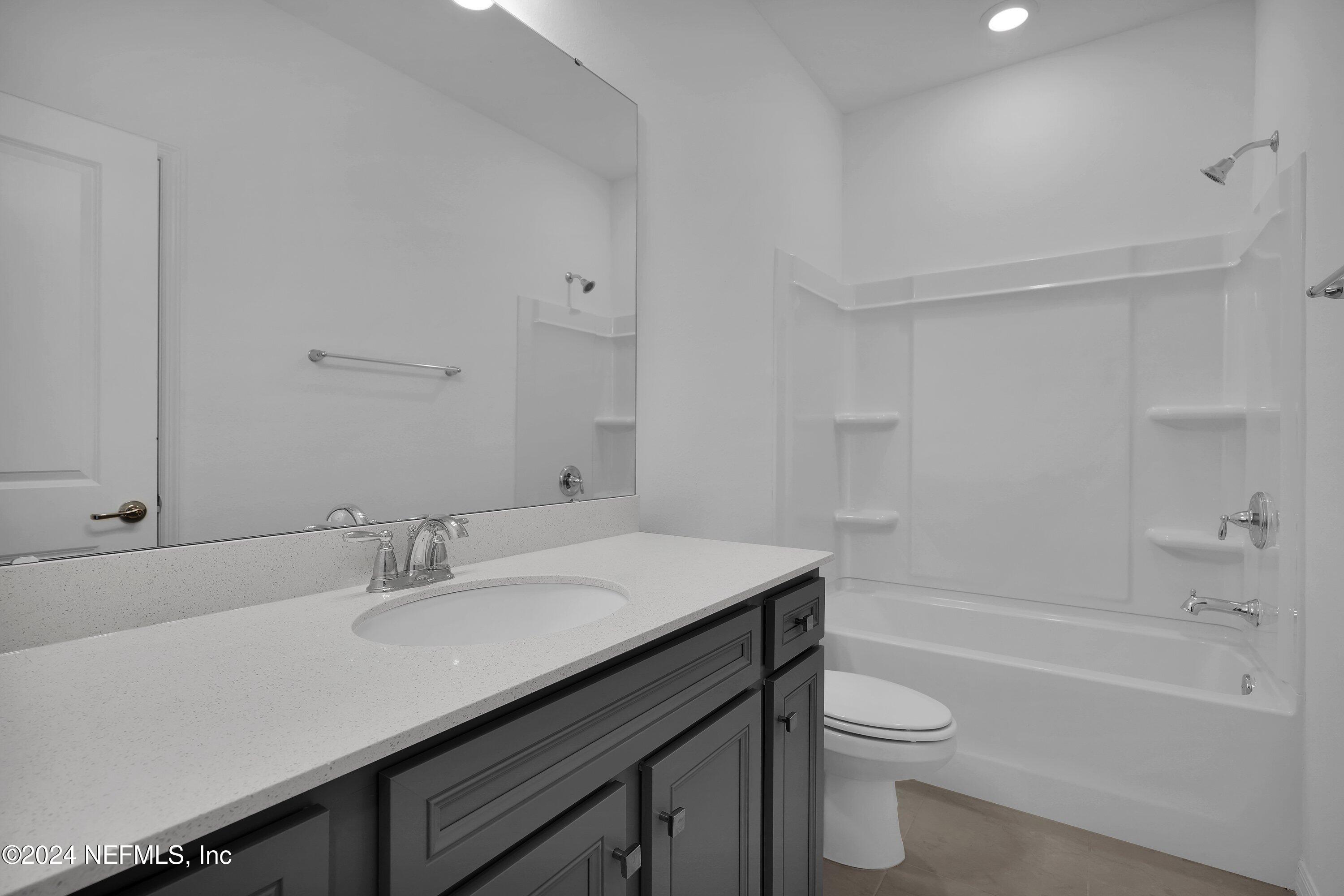 152 Flintlock Lane St. Augustine, FL 32095 - Photo 16 of 40 a bathroom with a sink a toilet a vanity and shower