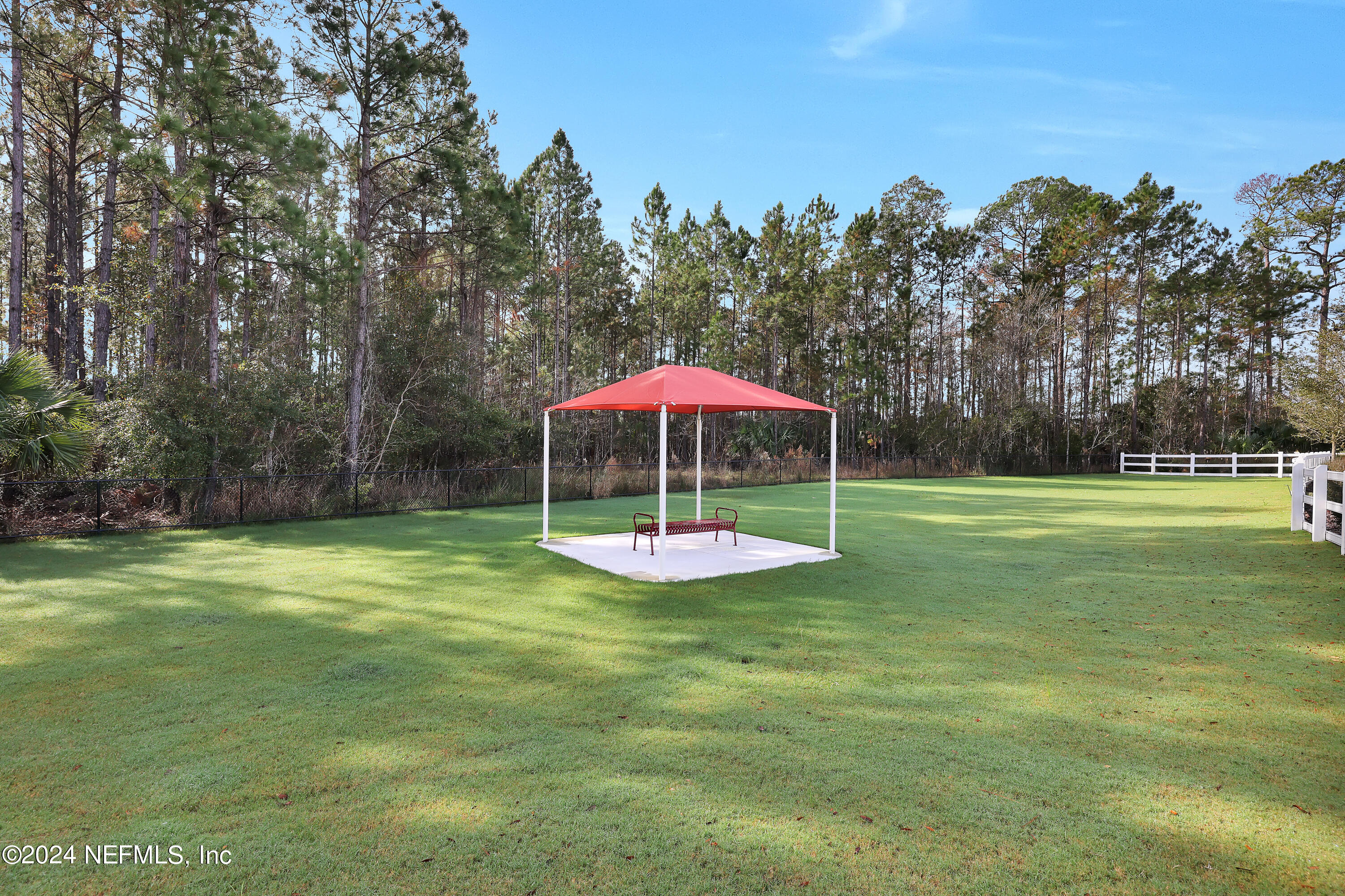 152 Flintlock Lane St. Augustine, FL 32095 - Photo 38 of 40 a table and chairs sitting in the middle of a yard