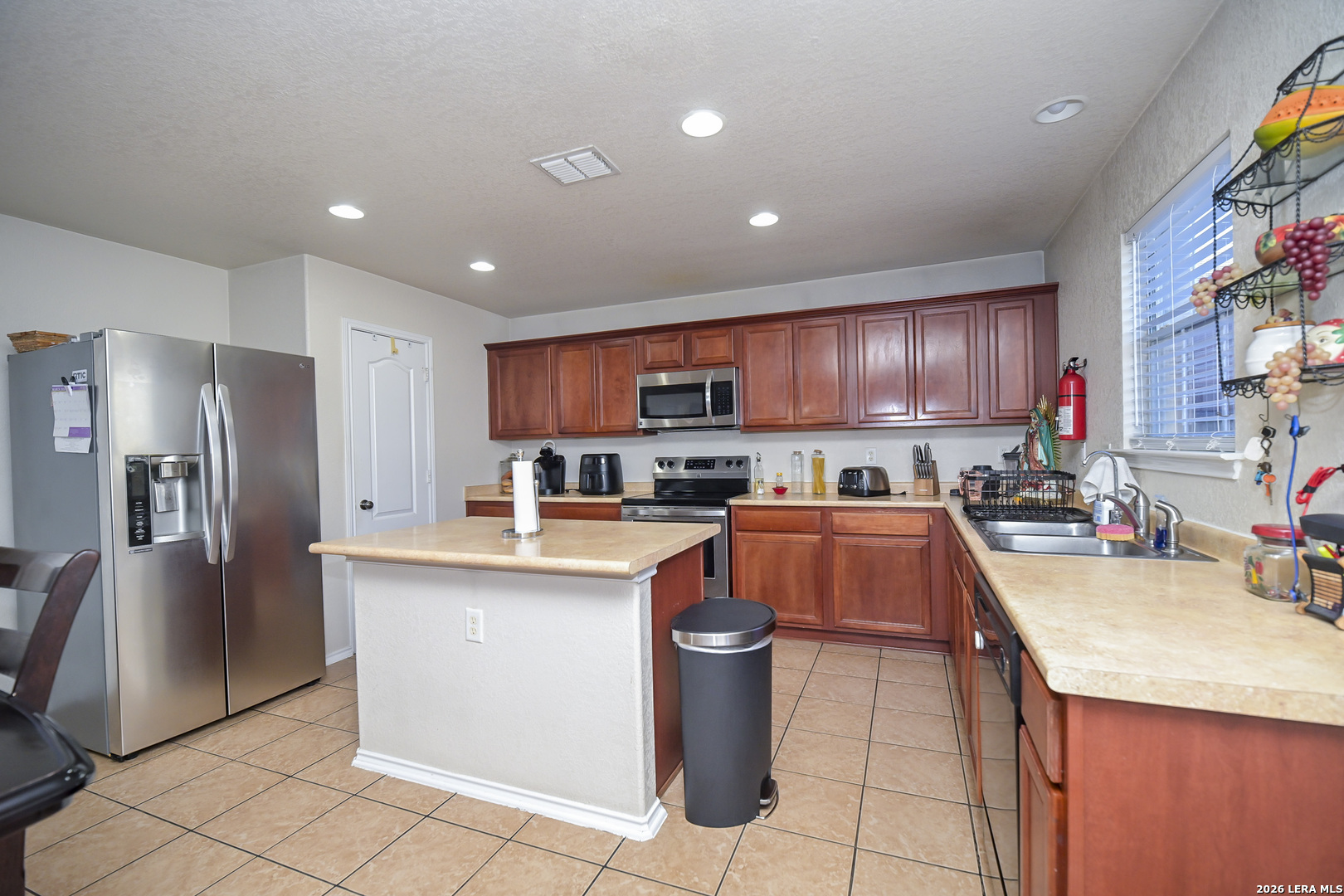7207 Avery Road Live Oak, TX 78233 - Photo 16 of 42 a kitchen with stainless steel appliances granite countertop a refrigerator a sink a stove a microwave and a refrigerator