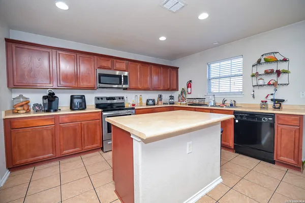 a kitchen with stainless steel appliances granite countertop a stove sink and cabinets