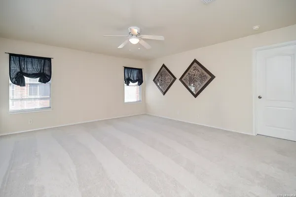 an empty room with windows and cabinet