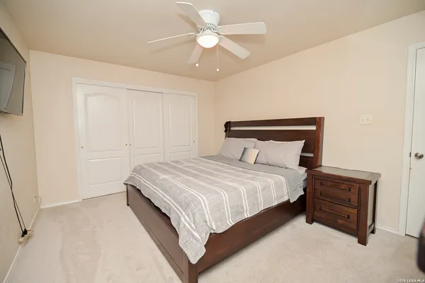 a bedroom with a bed and a ceiling fan