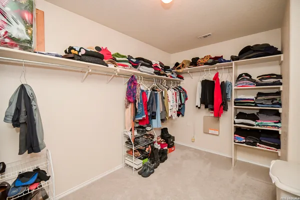 a view of walk in closet with clothes and shoes