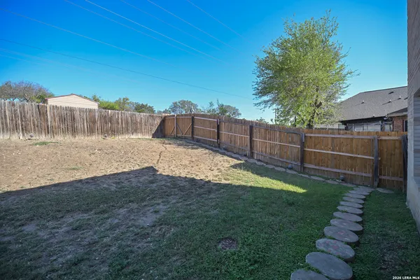 a view of a backyard with wooden fence