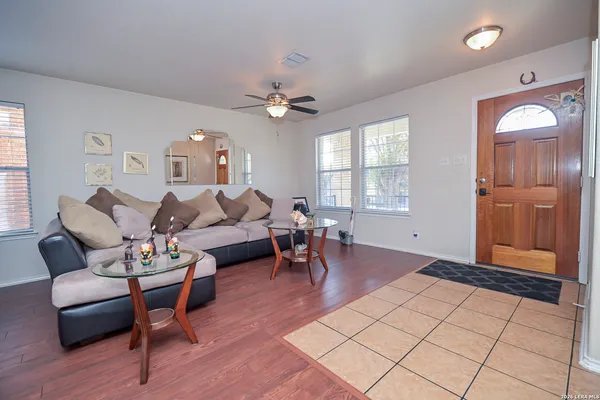 a living room with furniture a dining table and a chandelier