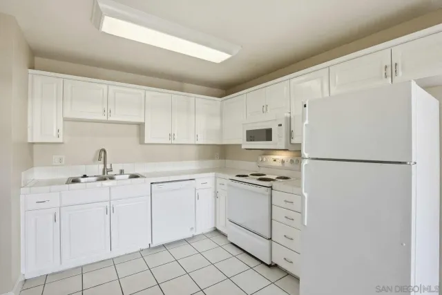 a kitchen with white cabinets sink and white appliances