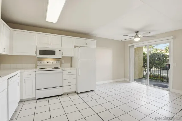 a kitchen with white cabinets and white appliances