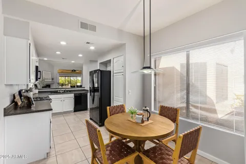 a kitchen with stainless steel appliances kitchen island granite countertop a refrigerator a sink a stove and white cabinets with wooden floor