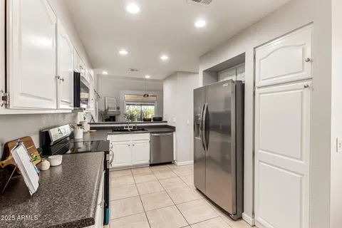 a kitchen with stainless steel appliances granite countertop a refrigerator a sink a stove and island