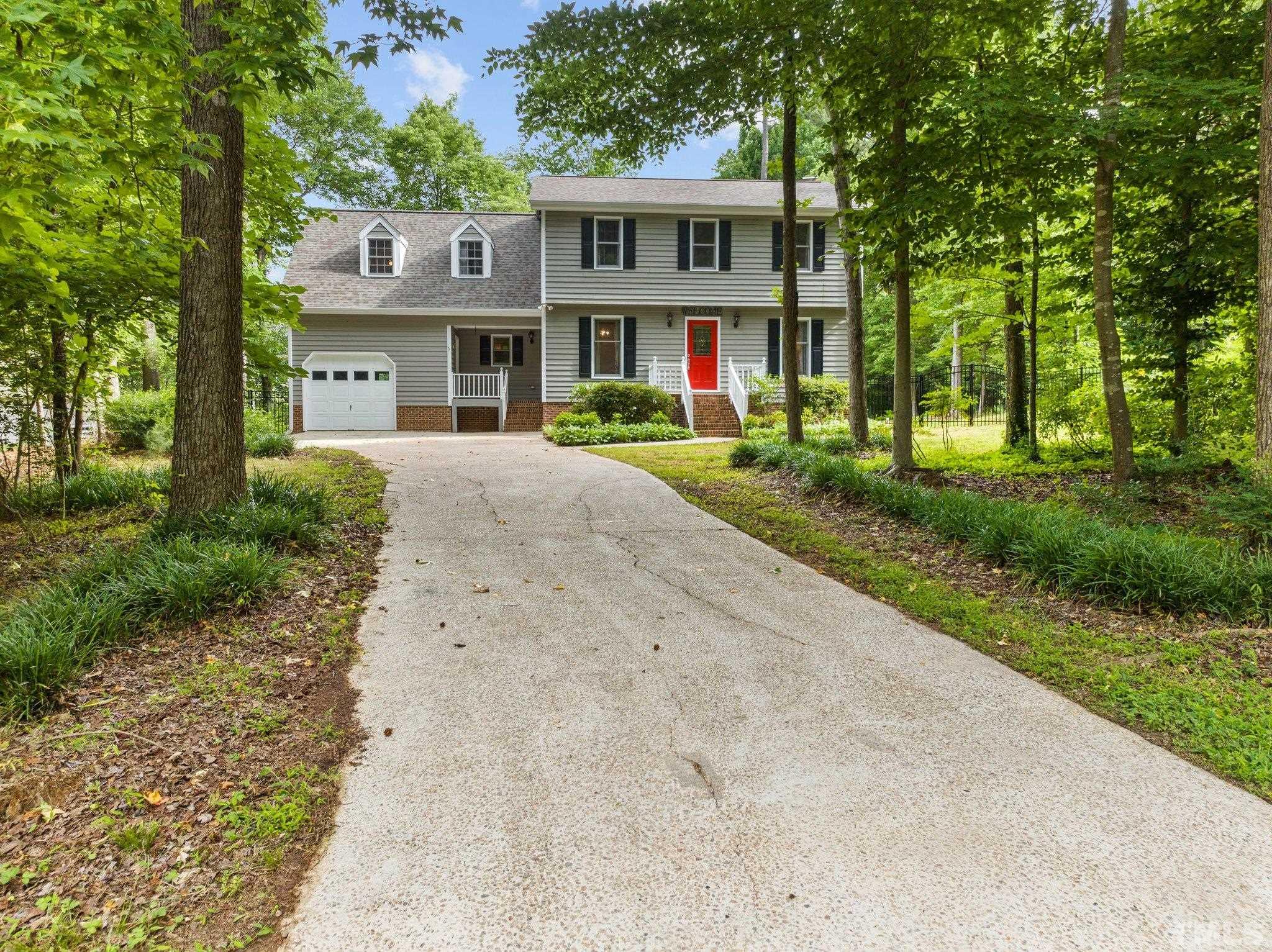 8317 Dunwood Court Raleigh, NC 27613 - Photo 1 of 50 a front view of a house with a yard and potted plants