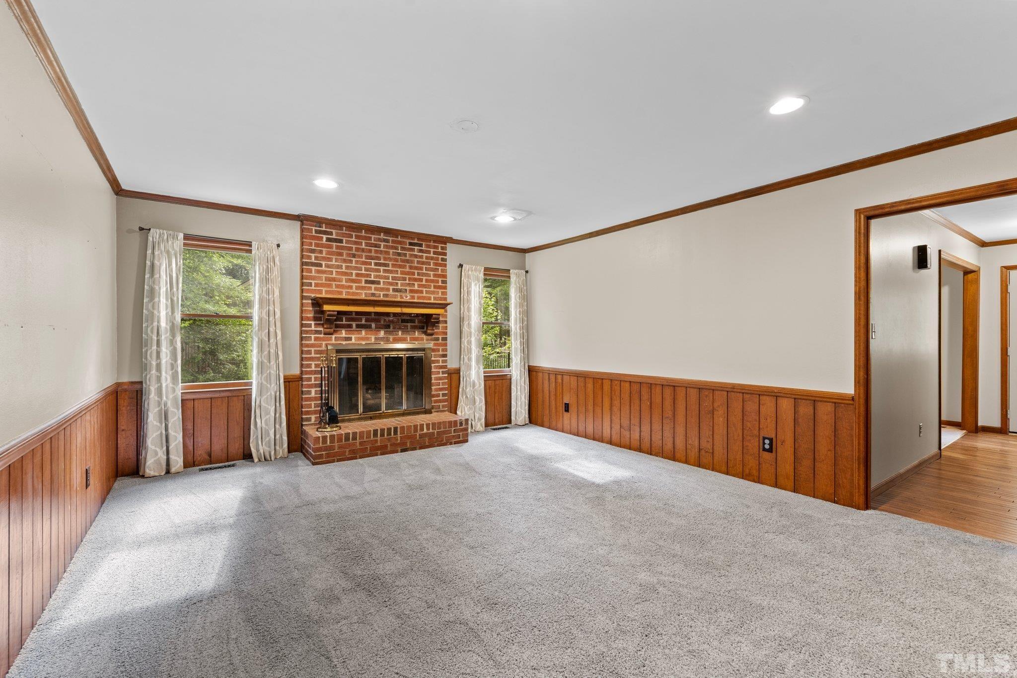 8317 Dunwood Court Raleigh, NC 27613 - Photo 11 of 50 an empty room with windows and a fireplace
