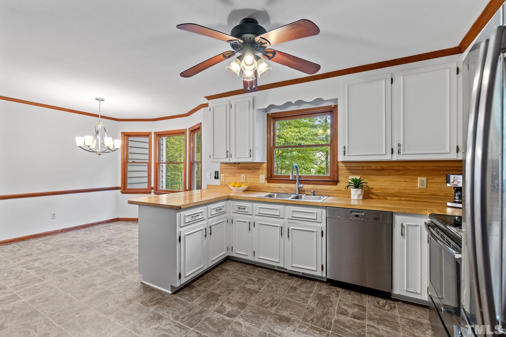 8317 Dunwood Court Raleigh, NC 27613 - Photo 12 of 50 a kitchen with a sink window and cabinets