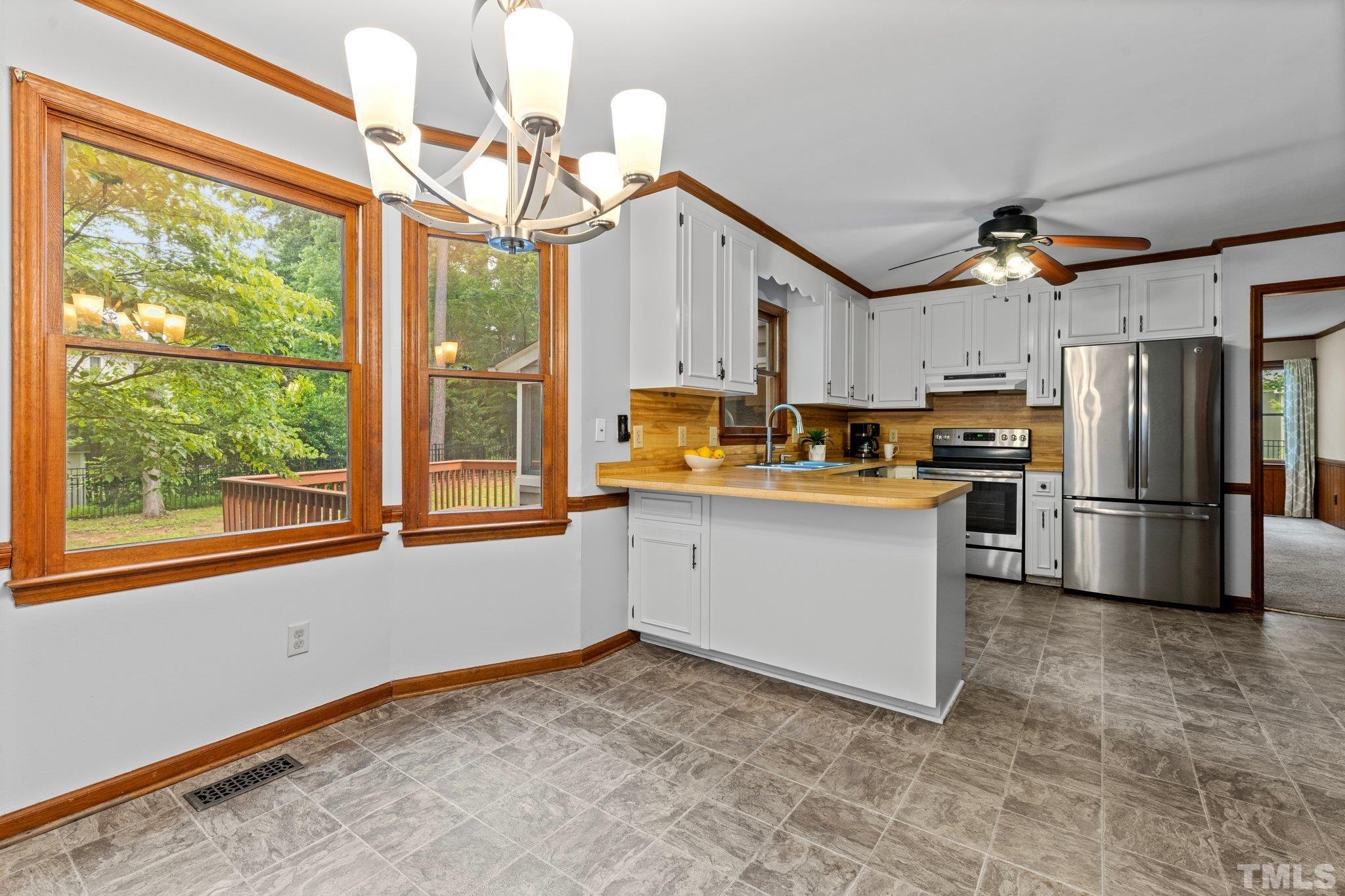 8317 Dunwood Court Raleigh, NC 27613 - Photo 14 of 50 a kitchen with a refrigerator a sink and dishwasher