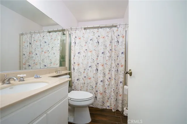 a bathroom with a sink a toilet and shower curtain