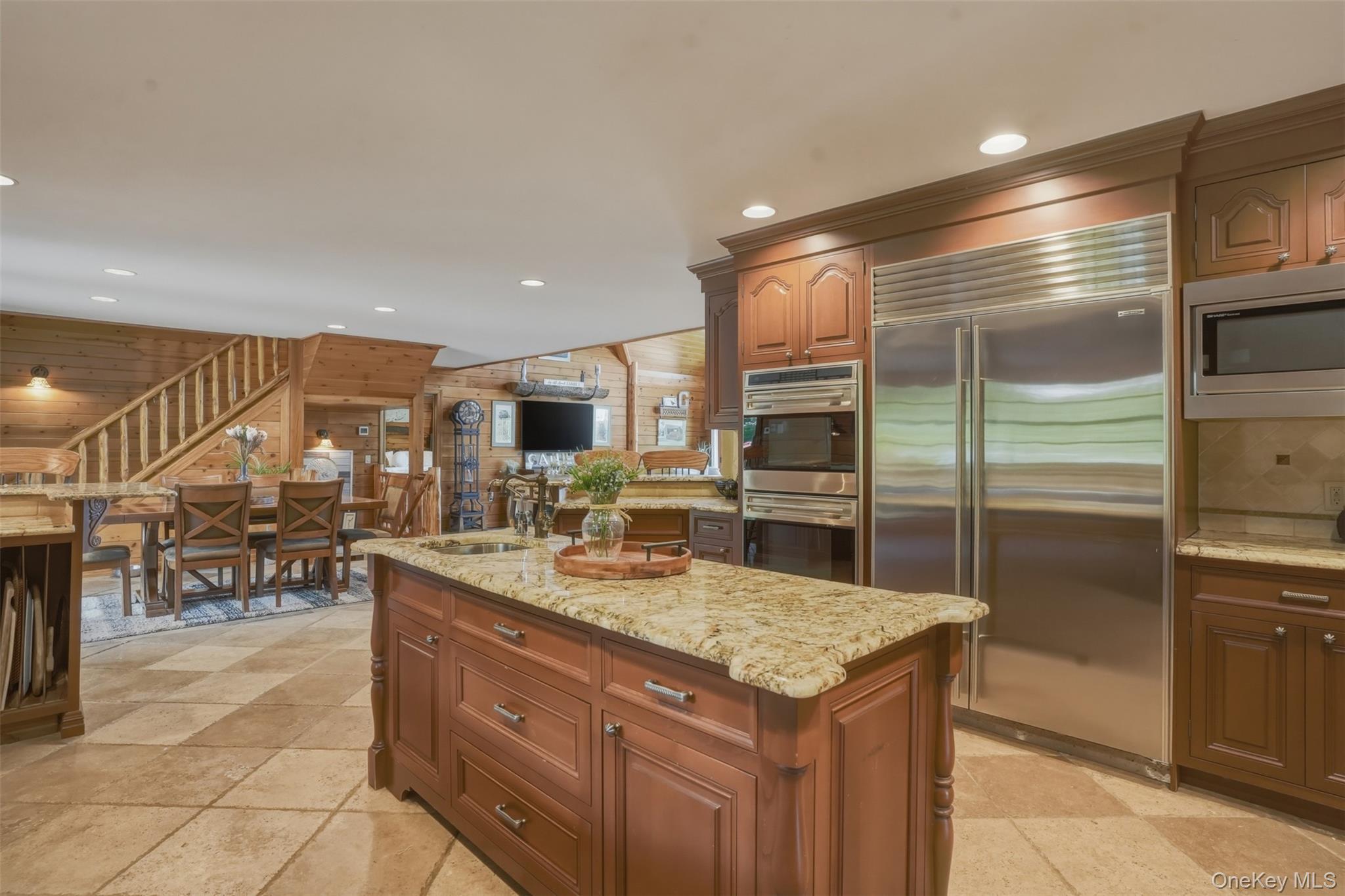 95 Judson Road Montgomery, NY 12549 - Photo 7 of 50 Inside, the home showcases rich wood craftsmanship, soaring ceilings, and breathtaking views of the surrounding mountains, koi ponds, and manicured gardens. The chef's kitchen features custom wood cabinetry, granite countertops, a center island, and spacious dining area, while a practical mudroom includes a convenient dog washing station.