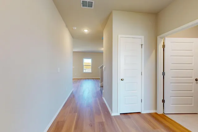 a view of a hallway with wooden floor