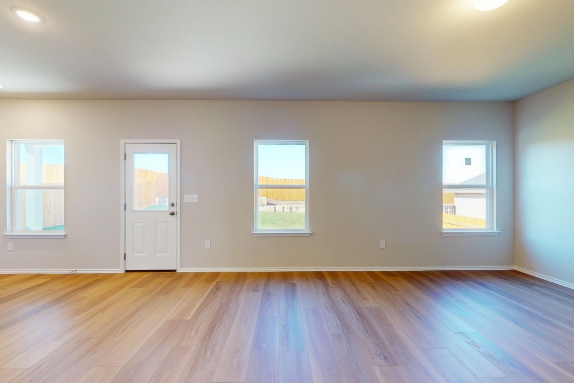 12300 Dillon Fls Drive Austin, TX 78747 - Photo 5 of 40 an empty room with wooden floor and windows