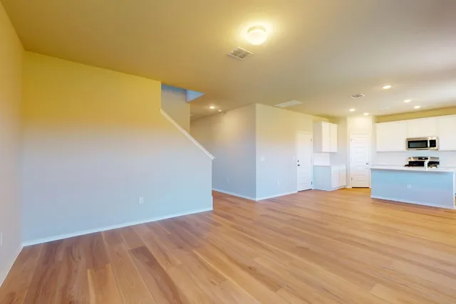 a view of a livingroom with kitchen and a window