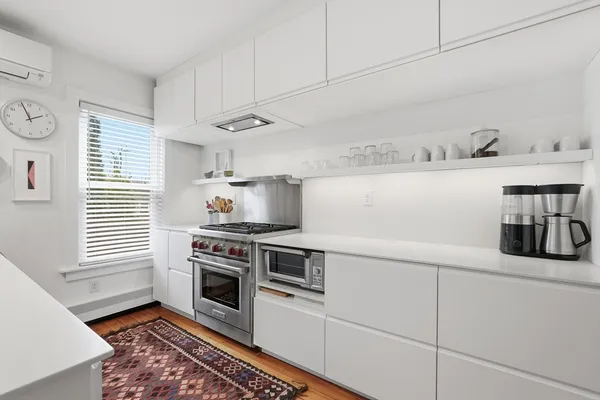 a kitchen with kitchen island white cabinets and white appliances