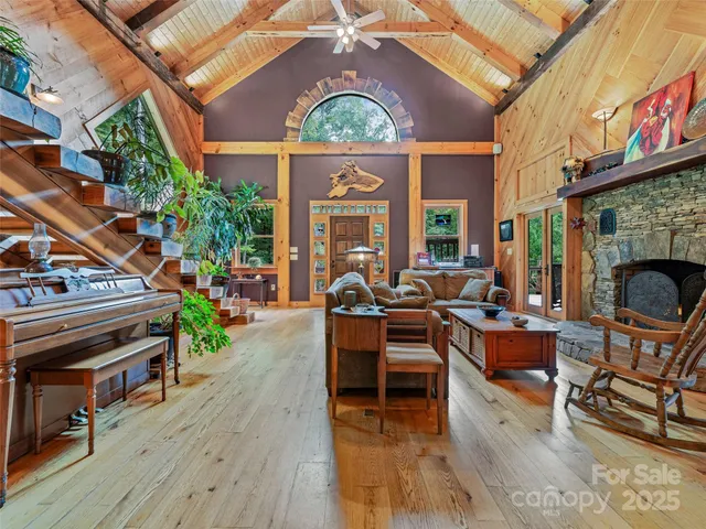 a living room with furniture a fireplace and a floor to ceiling window