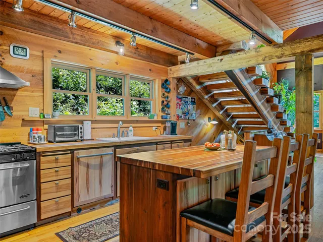 a view of a patio with table and chairs a barbeque with wooden floor and roof